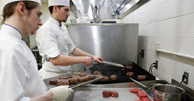 Culinary student prepare the beef tenderloin steak for the luncheon.